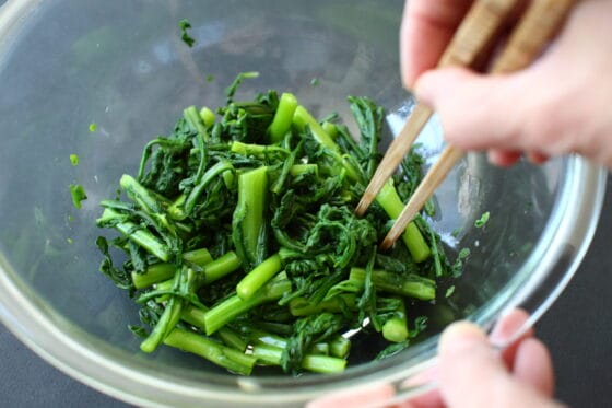ボウルに春菊を加えて調味液をなじませる