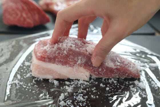 豚バラ塊肉に塩をまぶす