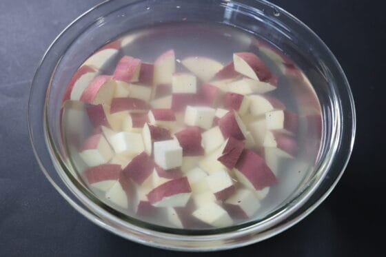 角切りにしたさつまいもを水にさらしてアク抜きする