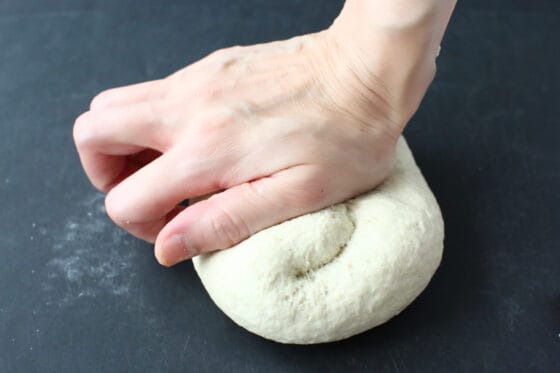そば粉パンの生地を台の上でしっかりこねる