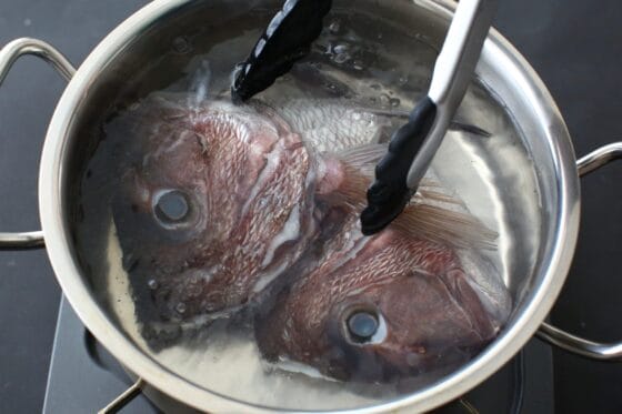 鯛の頭を鍋に入れて湯通しする