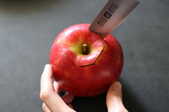 りんごの芯の周辺にペティナイフを刺す