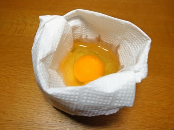 袋状にしたキッチンペーパーに卵を割り入れる