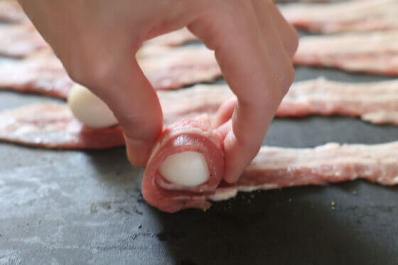うずらの卵を転がすようにして豚バラ肉を巻く
