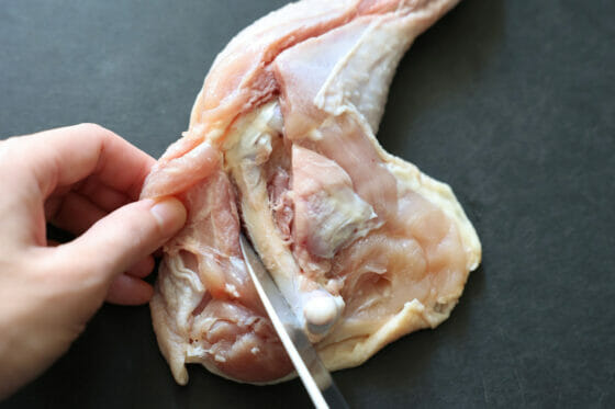 鶏もも肉の骨に沿って包丁を入れる
