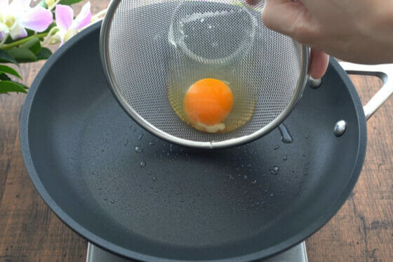 フライパンに卵を入れる