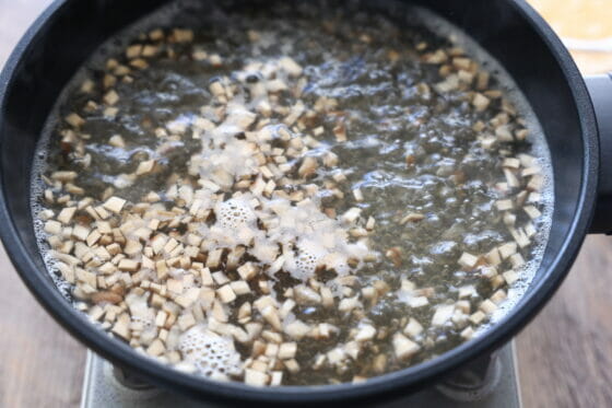鍋で水とだしの素と椎茸の軸を煮る