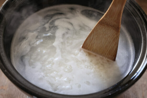 米と水と塩を鍋に入れて沸騰したらヘラで混ぜる
