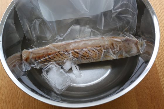 焼いたカツオをビニール袋に入れて氷水で冷やす