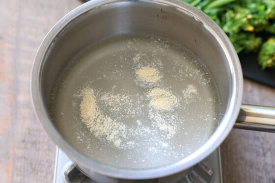 鶏ガラスープの素と水を鍋に入れる