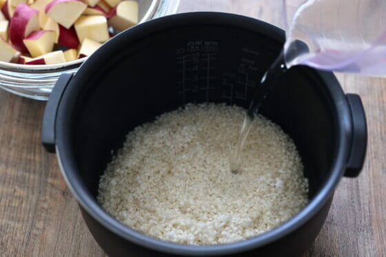 炊飯器に米とだし汁を入れる