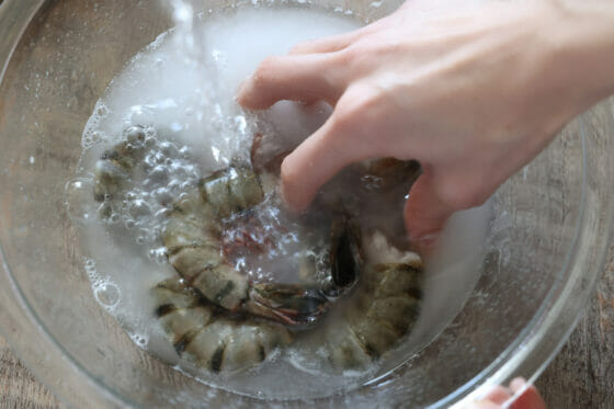 エビを流水に当てて片栗粉をきれいに洗い流す