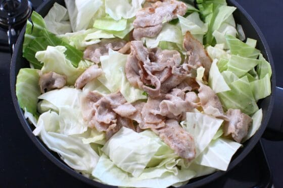 キャベツの芯の上にキャベツの葉と豚肉をのせる