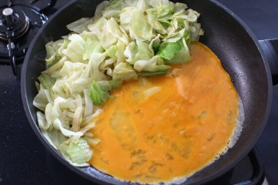 キャベツを端に寄せて卵液を加える