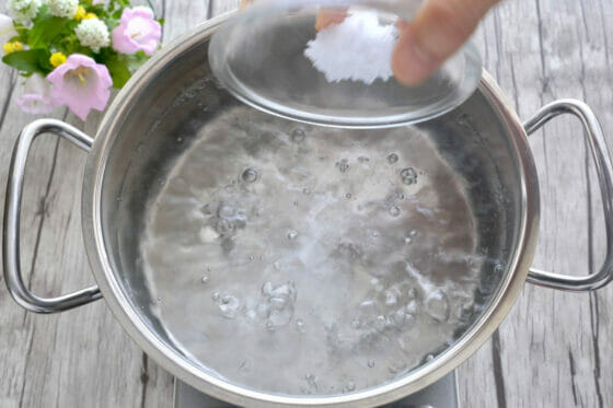 鍋で湧かした湯に塩を加える