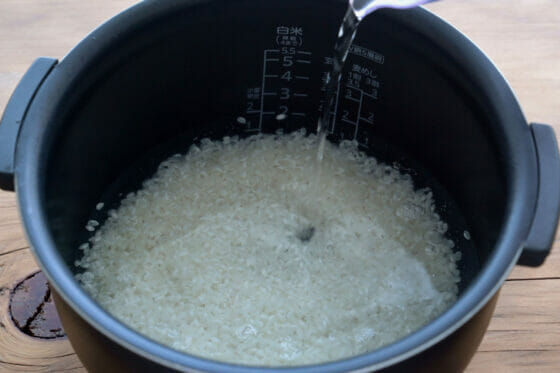 炊飯器に米と調味料と水を入れる
