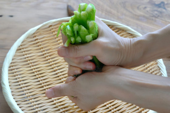茹でた小松菜を手で絞る