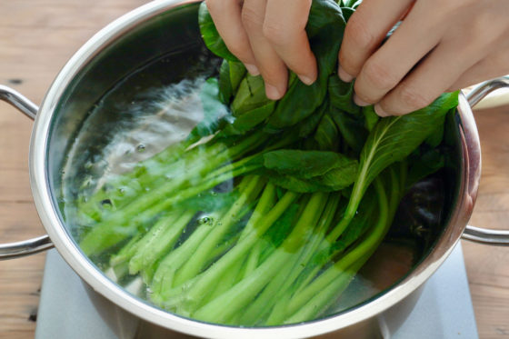 沸騰した湯に小松菜の茎の部分を浸す