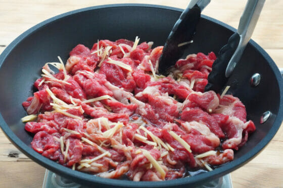 牛肉と生姜と調味料をフライパンに入れて混ぜる