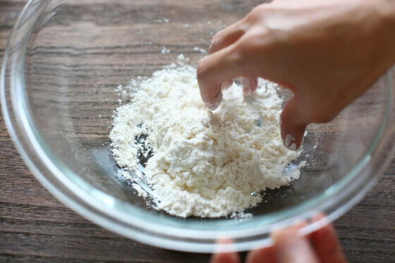 小麦粉に水を加えて手で混ぜる