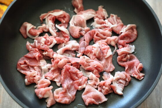 フライパンに豚細切れ肉を広げる