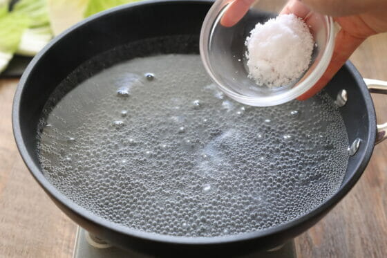 沸騰した湯に塩を加える
