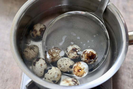 うずらの卵を鍋から取り出す