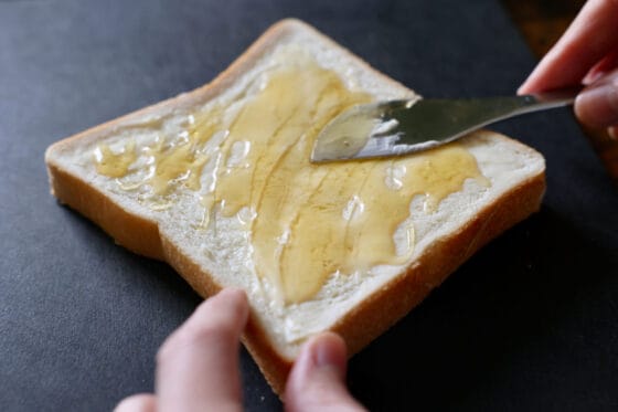 食パンにバターとはちみつを塗る