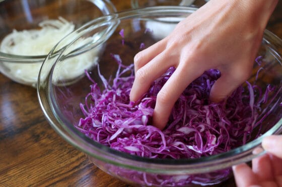 紫キャベツと玉ねぎに塩を揉み込む