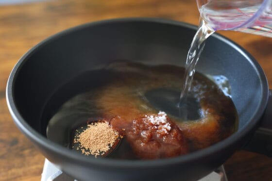 調味料と水を鍋に入れる