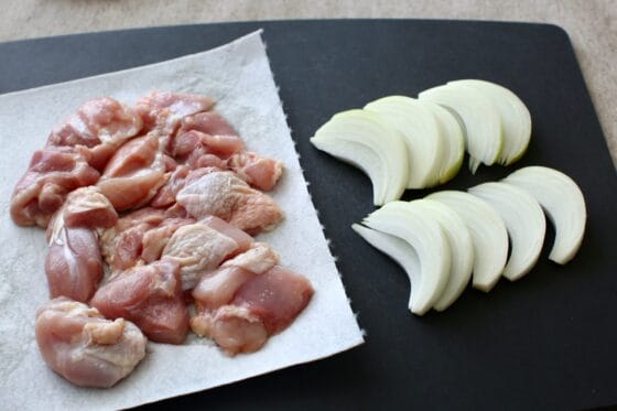 玉ねぎをくし切りにして鶏もも肉の水気をキッチンペーパーで取り除く