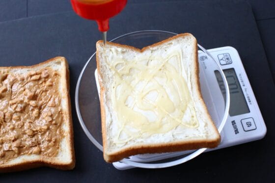 食パンの上ではちみつを計量する