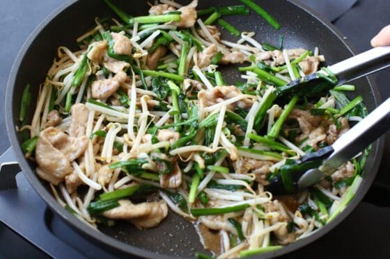 豚肉もやしニラ炒めにたれを加えて味を馴染ませる