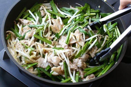 豚肉にもやしとニラを加えて手早く炒める