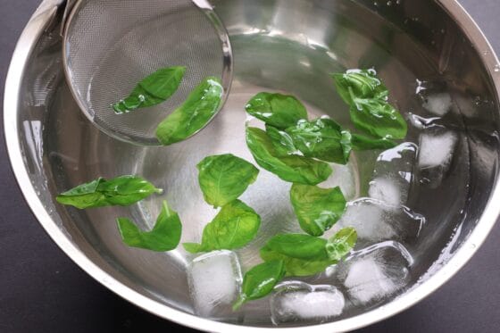 湯通ししたバジルの葉を冷水に取る