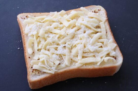 食パンにのせたピザ用チーズの上からパルミジャーノを振りかける