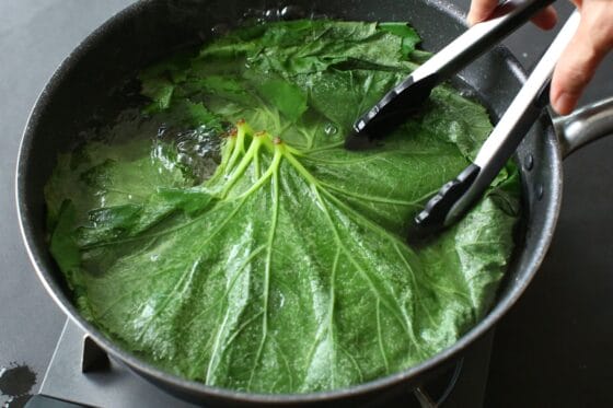 ふきの葉を鍋で茹でてアクを抜く
