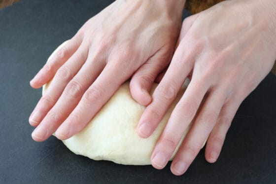 パン生地を手のひらで軽く押してガスを抜く