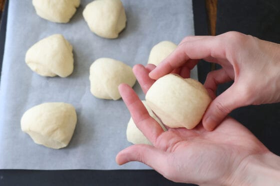 パン生地を軽く丸めてクッキングシートを敷いた台の上に並べる