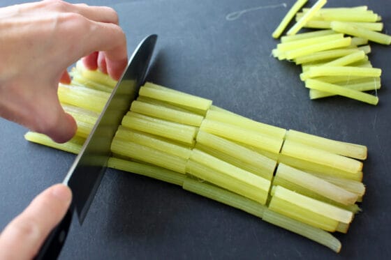 野ぶきの茎を包丁で切り分ける