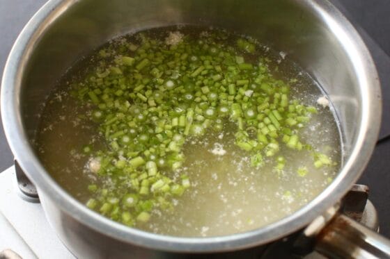 鍋ににんにくと生姜と鶏ガラスープの素と水とパクチーの茎を入れて火にかける