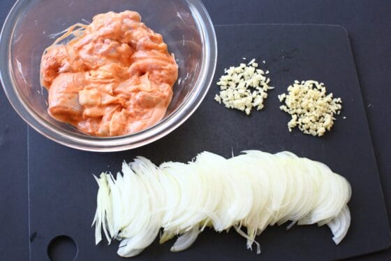 鶏もも肉に下味をつけて玉ねぎとニンニクと生姜を切る