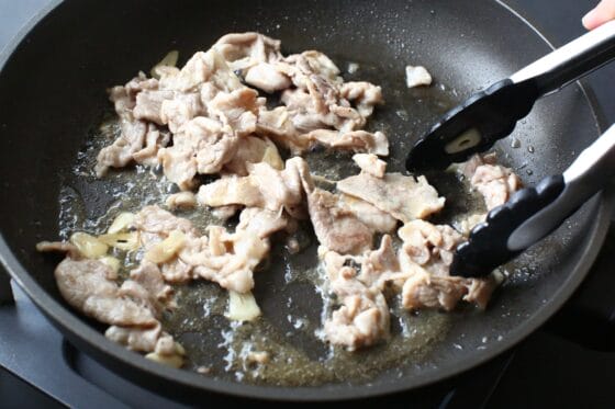酒と鶏ガラスープの素を加えて豚肉と炒め合わせる
