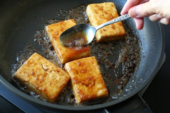 焼き上がった豆腐にソースを加えてスプーンでかけながら煮詰める