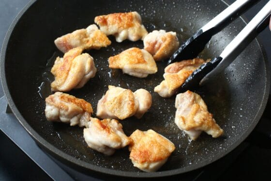 加熱した鶏もも肉をトングで裏返す