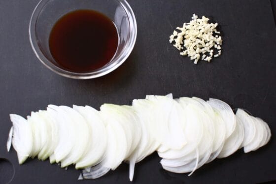 玉ねぎを薄切りに、にんにくをみじん切りにして、調味料をボウルに入れてタレを作る
