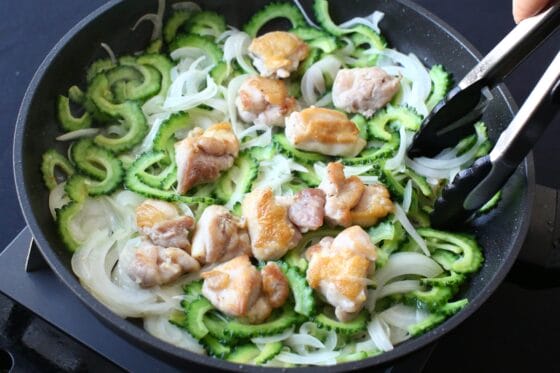 フライパンにゴーヤと玉ねぎを加えて鶏肉と炒める