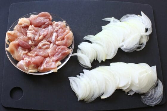 一口大に切った鶏もも肉と薄切りにした玉ねぎを準備する