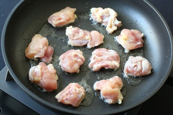 フライパンで鶏もも肉を皮目から中火で焼く