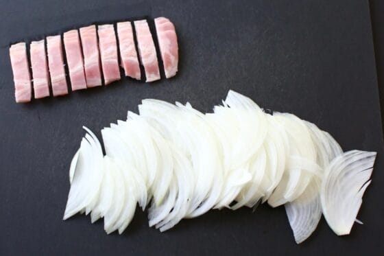 玉ねぎを薄切り、ベーコンを短冊切りにする